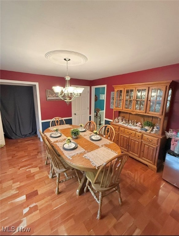 dining room with light hardwood / wood-style floors and a chandelier