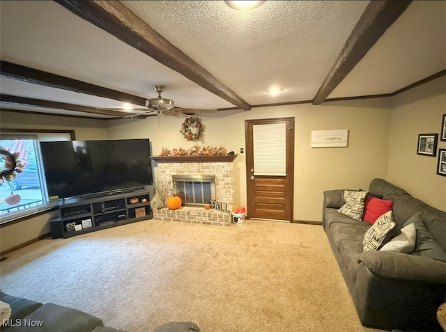 living room featuring a textured ceiling, a brick fireplace, ceiling fan, beam ceiling, and carpet