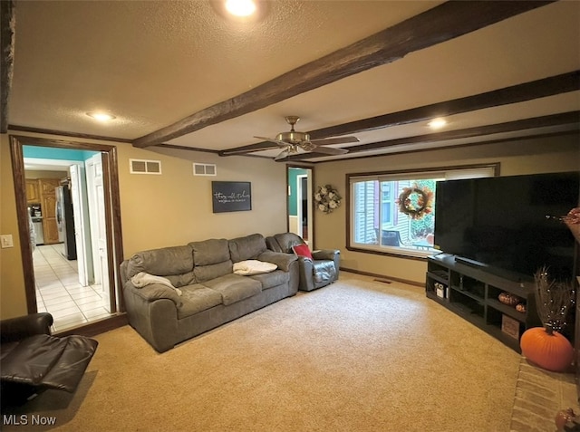 living room featuring beam ceiling, light carpet, a textured ceiling, and ceiling fan