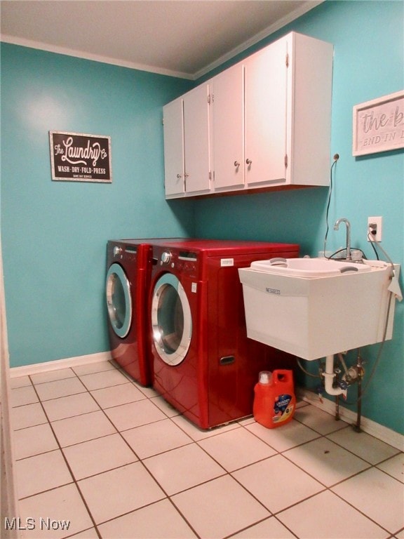 laundry room with ornamental molding, light tile patterned floors, separate washer and dryer, and cabinets