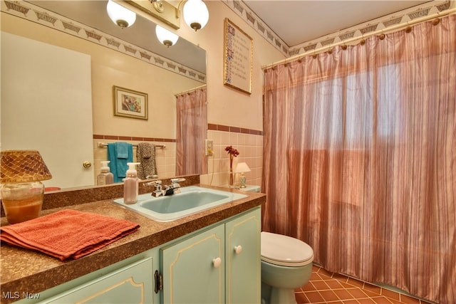 bathroom with a shower with curtain, vanity, tile walls, tile patterned flooring, and toilet