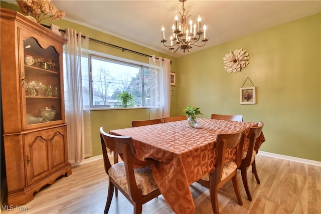 dining space featuring light hardwood / wood-style floors and a chandelier