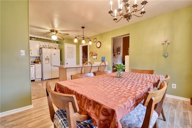 dining area featuring ceiling fan with notable chandelier and light hardwood / wood-style floors