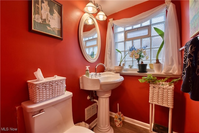 bathroom featuring hardwood / wood-style floors and toilet