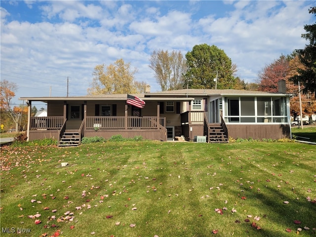 back of house with a yard and a sunroom