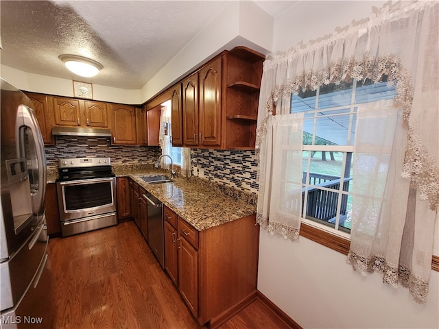 kitchen with appliances with stainless steel finishes, sink, dark wood-type flooring, and plenty of natural light