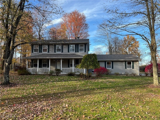 colonial home featuring a porch and a front lawn