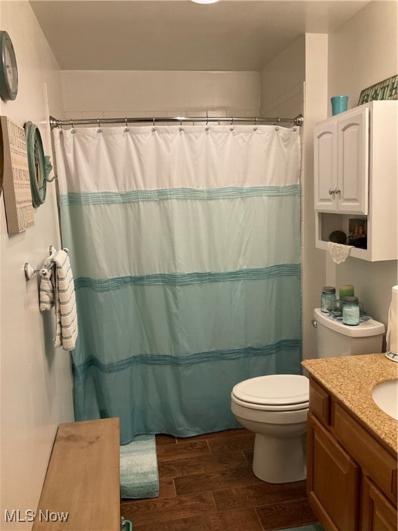 bathroom featuring vanity, a shower with curtain, hardwood / wood-style flooring, and toilet