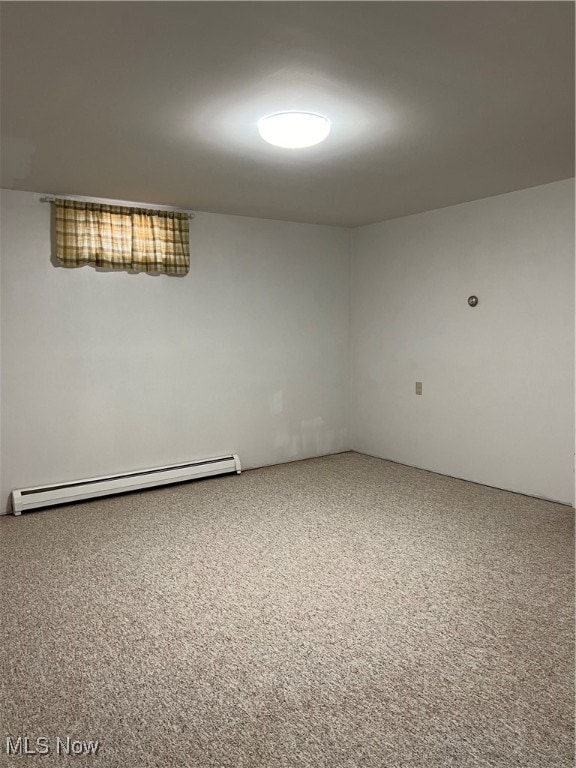 carpeted empty room with a baseboard heating unit