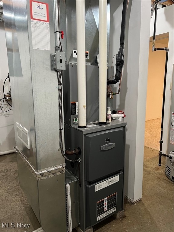 utility room featuring water heater and heating unit