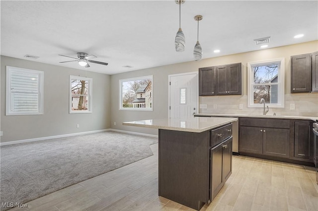 kitchen featuring a center island, pendant lighting, light wood-type flooring, and sink