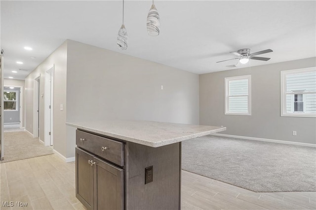 kitchen featuring pendant lighting, light hardwood / wood-style flooring, ceiling fan, and a healthy amount of sunlight