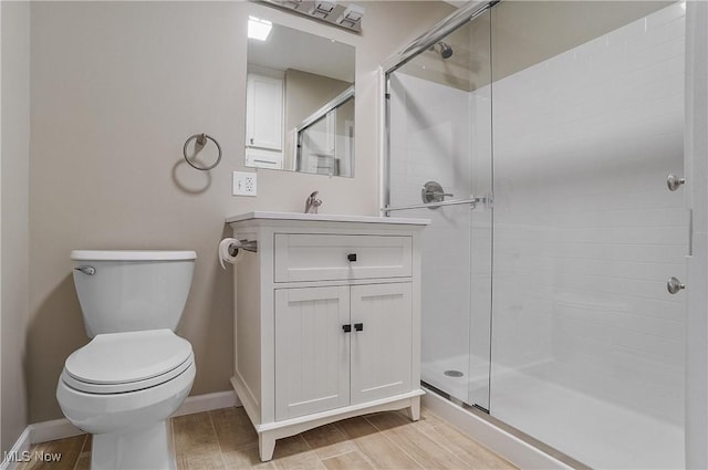 bathroom featuring vanity, a shower with shower door, and toilet