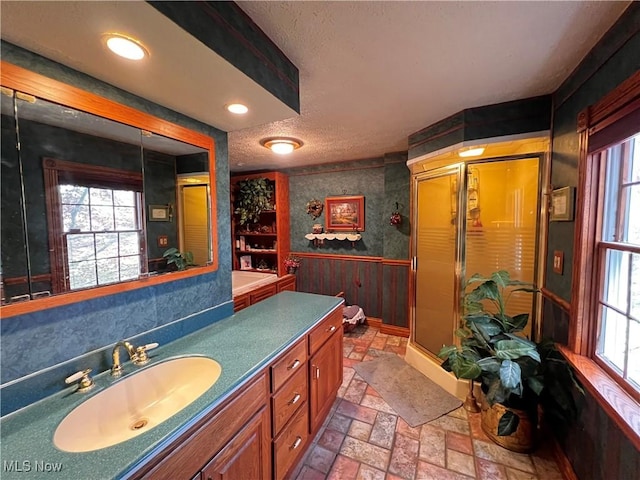 bathroom with walk in shower, vanity, a textured ceiling, and built in shelves