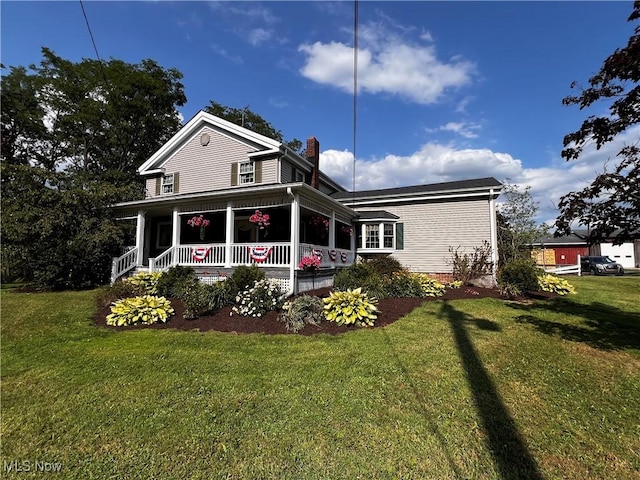 rear view of house with a lawn, covered porch, and a chimney