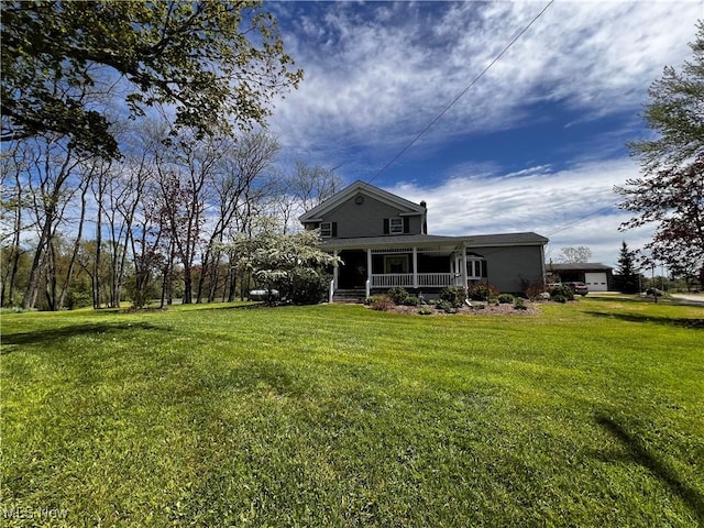 rear view of property featuring a yard and a porch