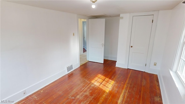 unfurnished bedroom with a closet and dark wood-type flooring