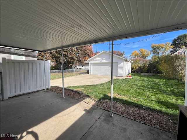 view of patio / terrace featuring a garage and an outbuilding