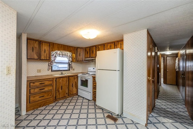 kitchen with sink, white appliances, and tasteful backsplash