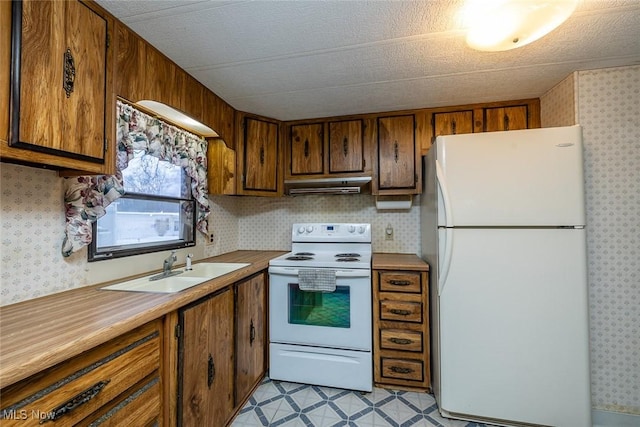 kitchen with white appliances, a textured ceiling, and sink