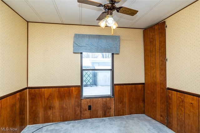 unfurnished room with ceiling fan and carpet