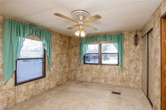 carpeted spare room with ceiling fan