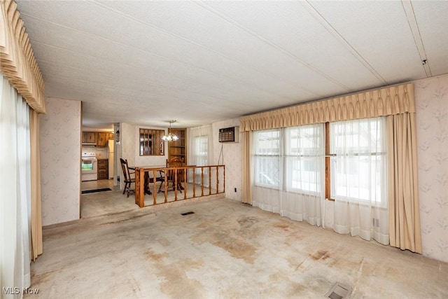 empty room with a chandelier and light colored carpet