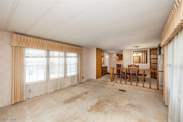 dining area featuring a notable chandelier and light carpet