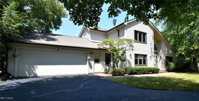 view of front of property with a front yard and a garage