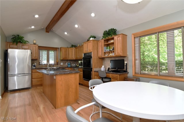 kitchen featuring a kitchen island, vaulted ceiling with beams, light hardwood / wood-style flooring, appliances with stainless steel finishes, and tasteful backsplash