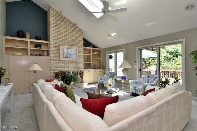 carpeted living room with ceiling fan, high vaulted ceiling, and a brick fireplace