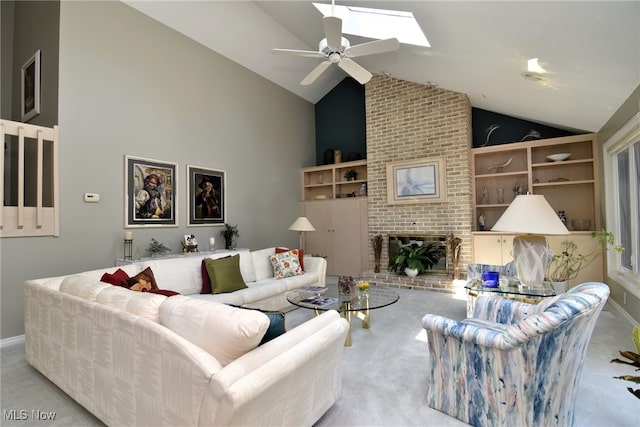 carpeted living room featuring lofted ceiling with skylight, a fireplace, and ceiling fan