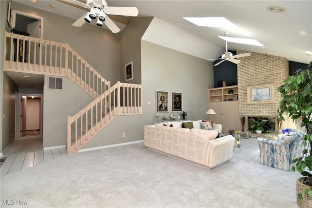 living room with carpet floors, high vaulted ceiling, a skylight, and a brick fireplace