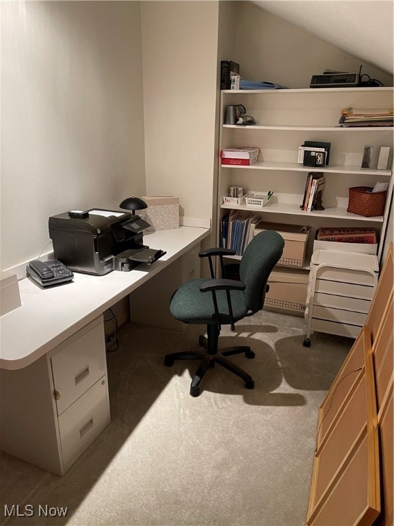 office space featuring light colored carpet and vaulted ceiling