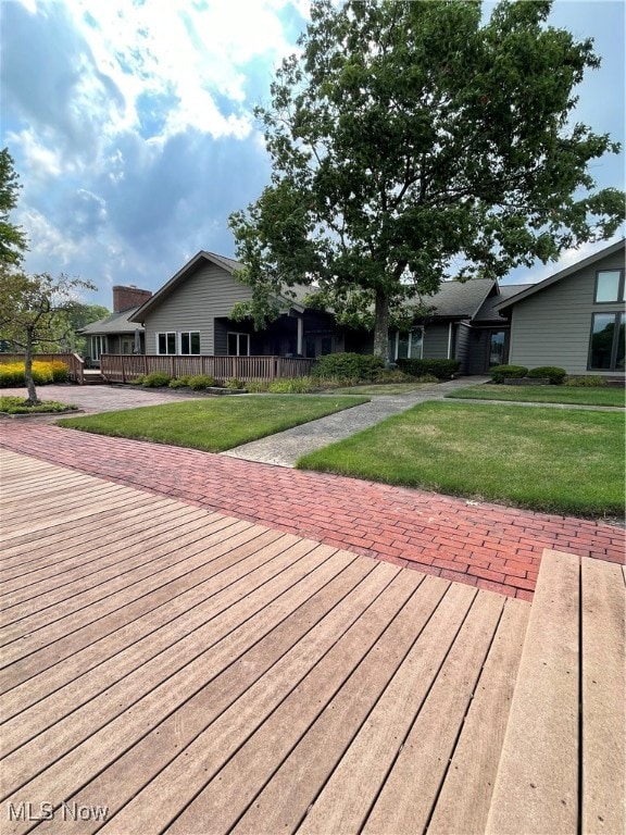 wooden deck featuring a lawn