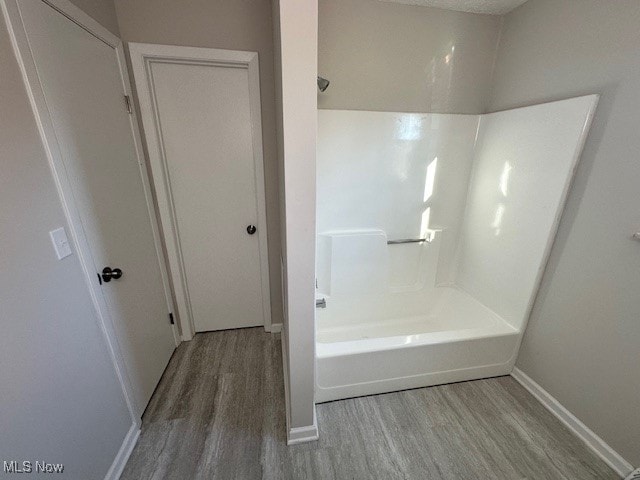 bathroom featuring hardwood / wood-style flooring and tub / shower combination