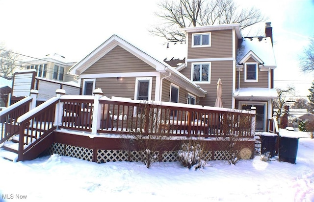 snow covered property with a wooden deck