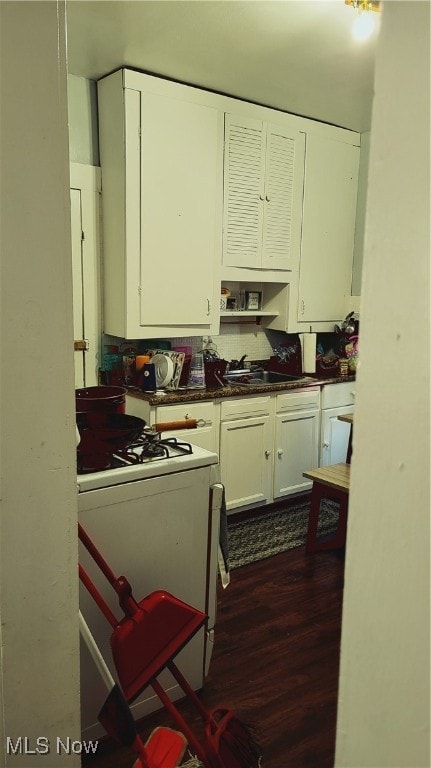 kitchen featuring white cabinets, dark hardwood / wood-style flooring, white range with gas cooktop, and sink