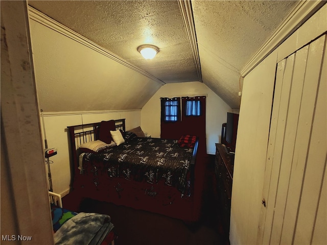 bedroom with lofted ceiling and a textured ceiling