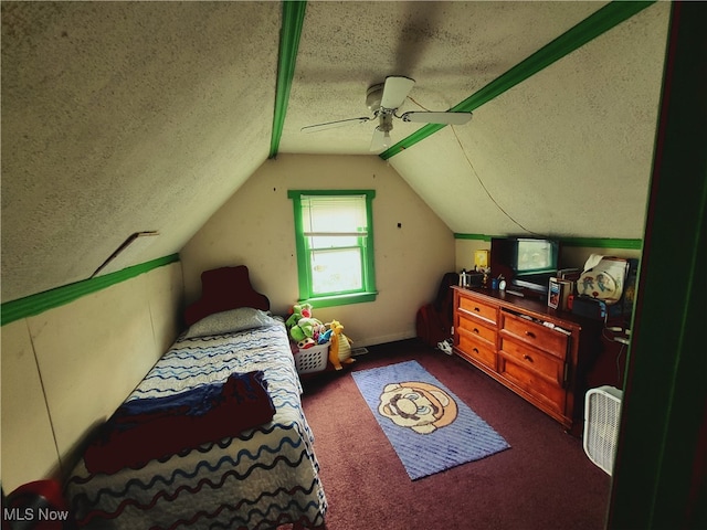 bedroom featuring lofted ceiling, a textured ceiling, dark carpet, and ceiling fan