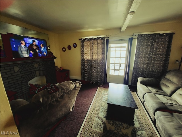 cinema with beam ceiling, dark carpet, and a fireplace