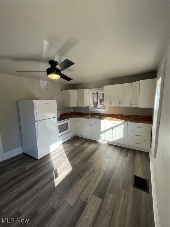 kitchen featuring white appliances, sink, dark hardwood / wood-style flooring, ceiling fan, and white cabinets