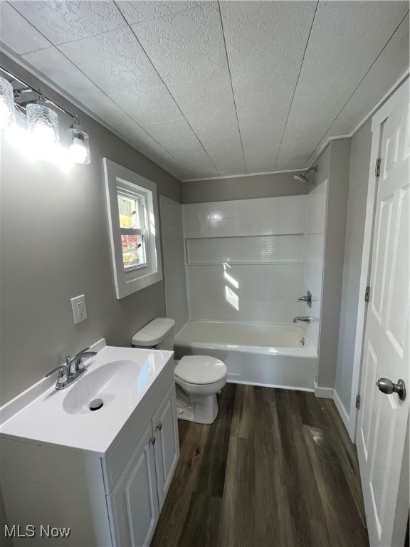 full bathroom featuring vanity, toilet,  shower combination, and hardwood / wood-style floors