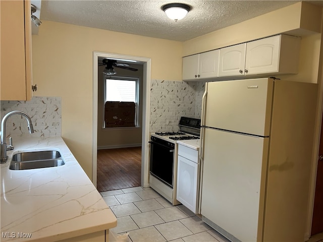 kitchen with white cabinetry, sink, tasteful backsplash, light hardwood / wood-style flooring, and white appliances