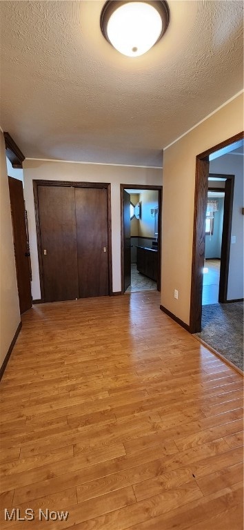 interior space with a textured ceiling and light wood-type flooring