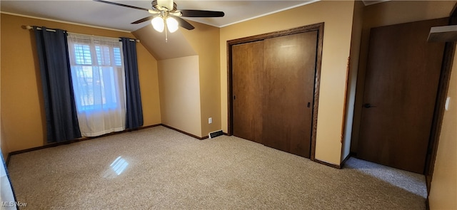 unfurnished bedroom with a closet, lofted ceiling, crown molding, and ceiling fan