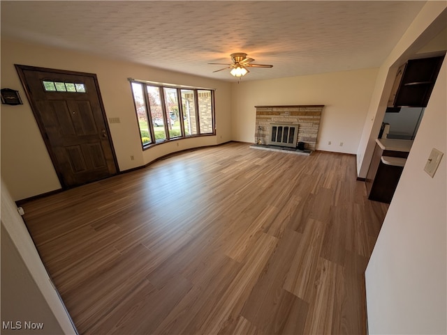 unfurnished living room with a textured ceiling, light hardwood / wood-style floors, and ceiling fan