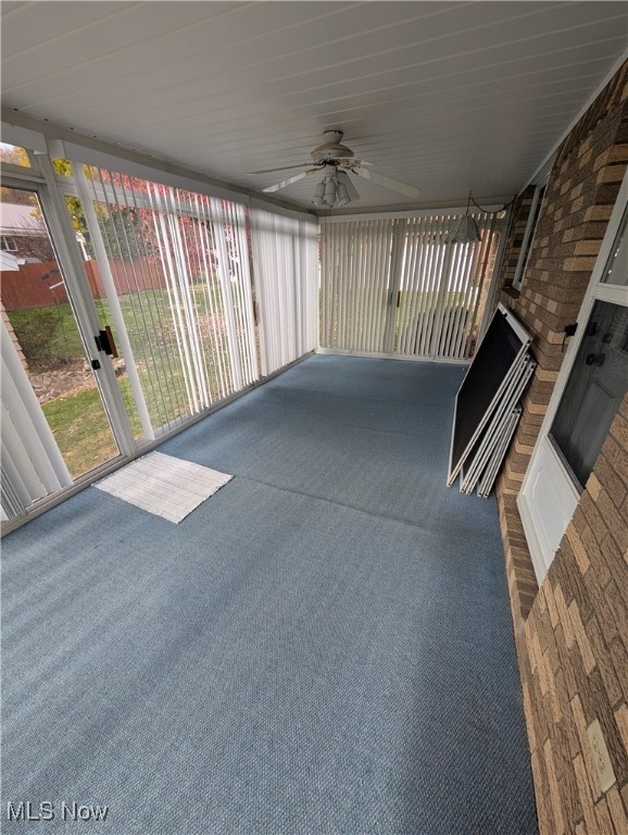 unfurnished sunroom featuring ceiling fan