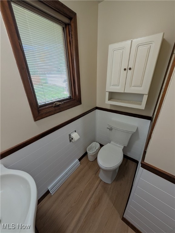 bathroom with toilet, hardwood / wood-style floors, sink, and tile walls