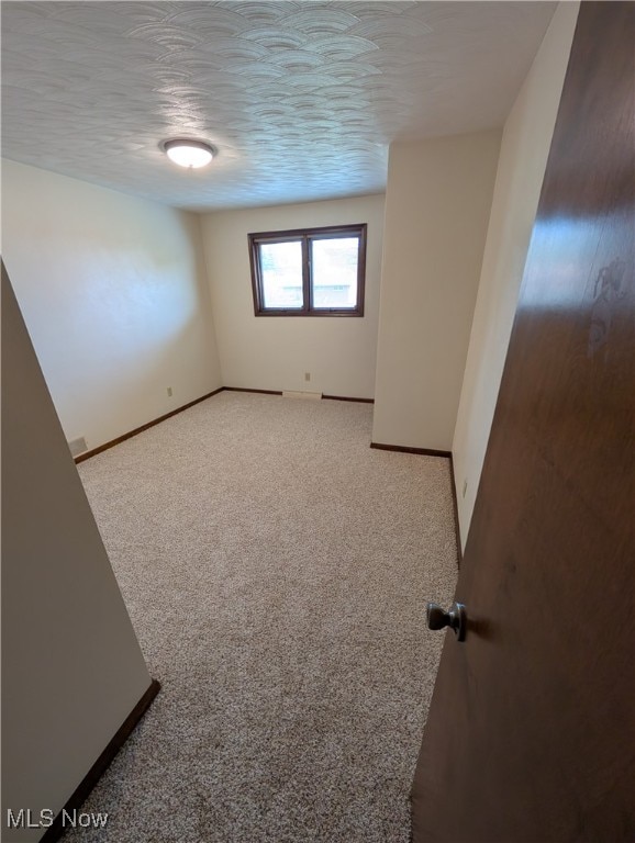 carpeted spare room with a textured ceiling